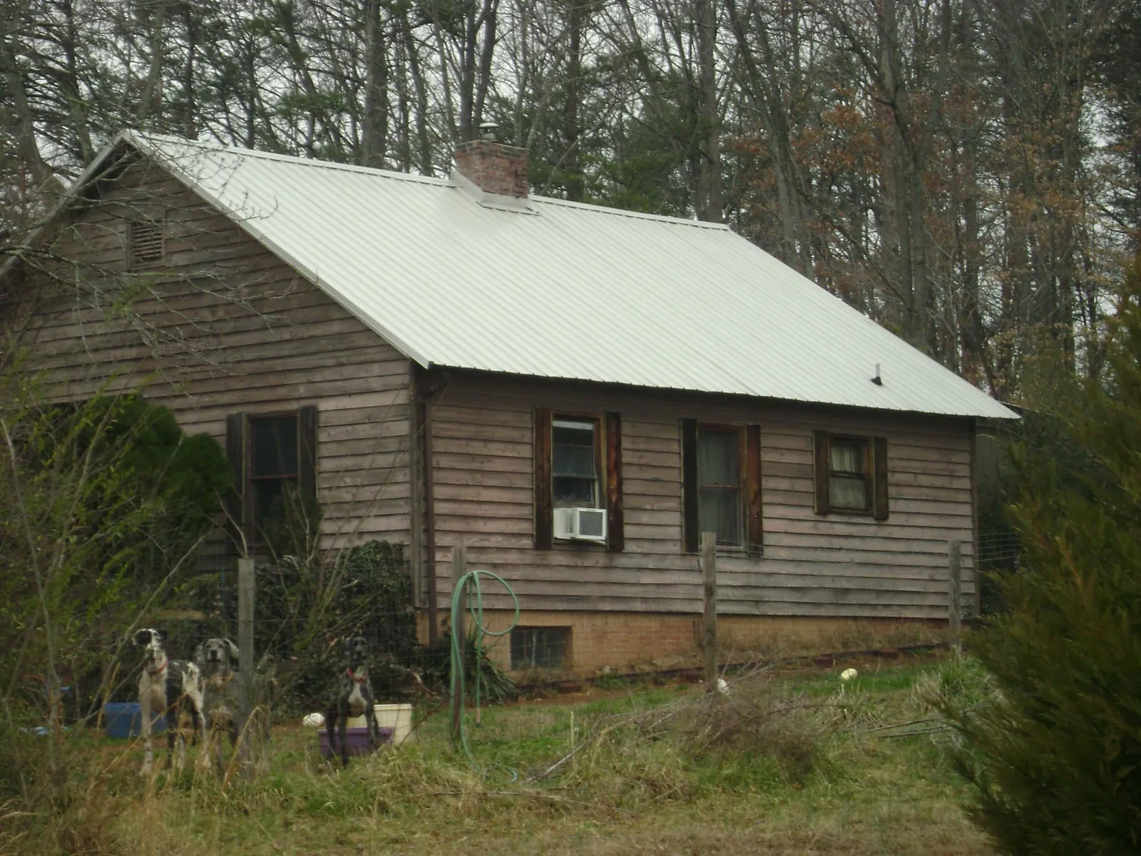 White metal roof on an old wood sided farmhouse, from a Metal Roof Installation job in Comstock